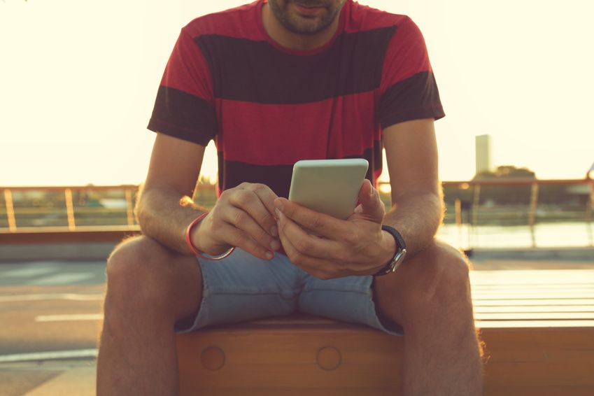 Ein Mann benutzt eine Dating-App auf seinem Handy auf der Suche nach einem Partner 