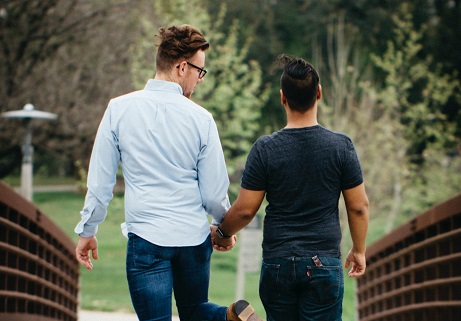 ein schwules Paar, das Händchen hält und spazieren geht