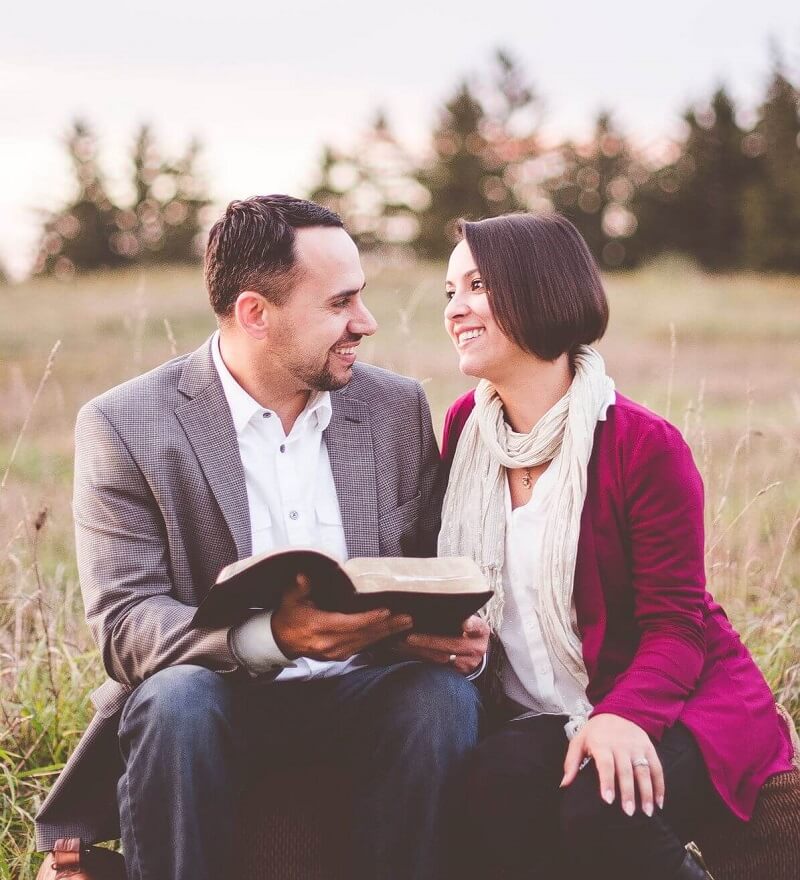 Verliebtes Paar, das gemeinsam eine Bibel liest